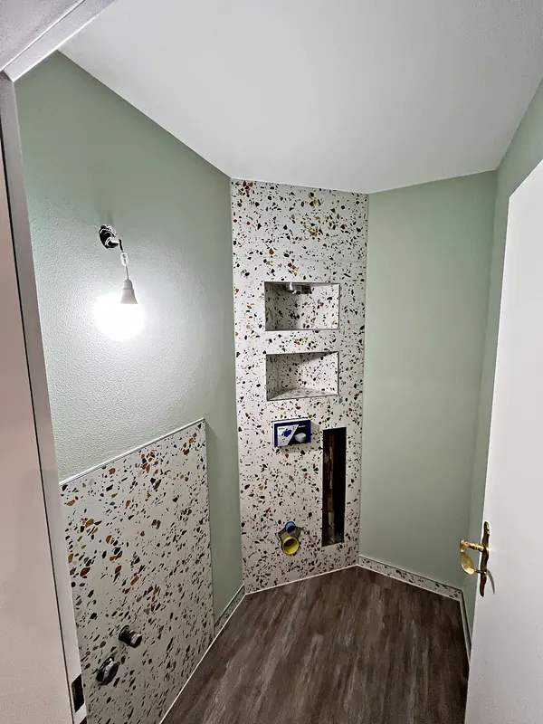 Ausgeführtes Gäste-WC mit Terrazzo-Fliesen und zwei Nischen